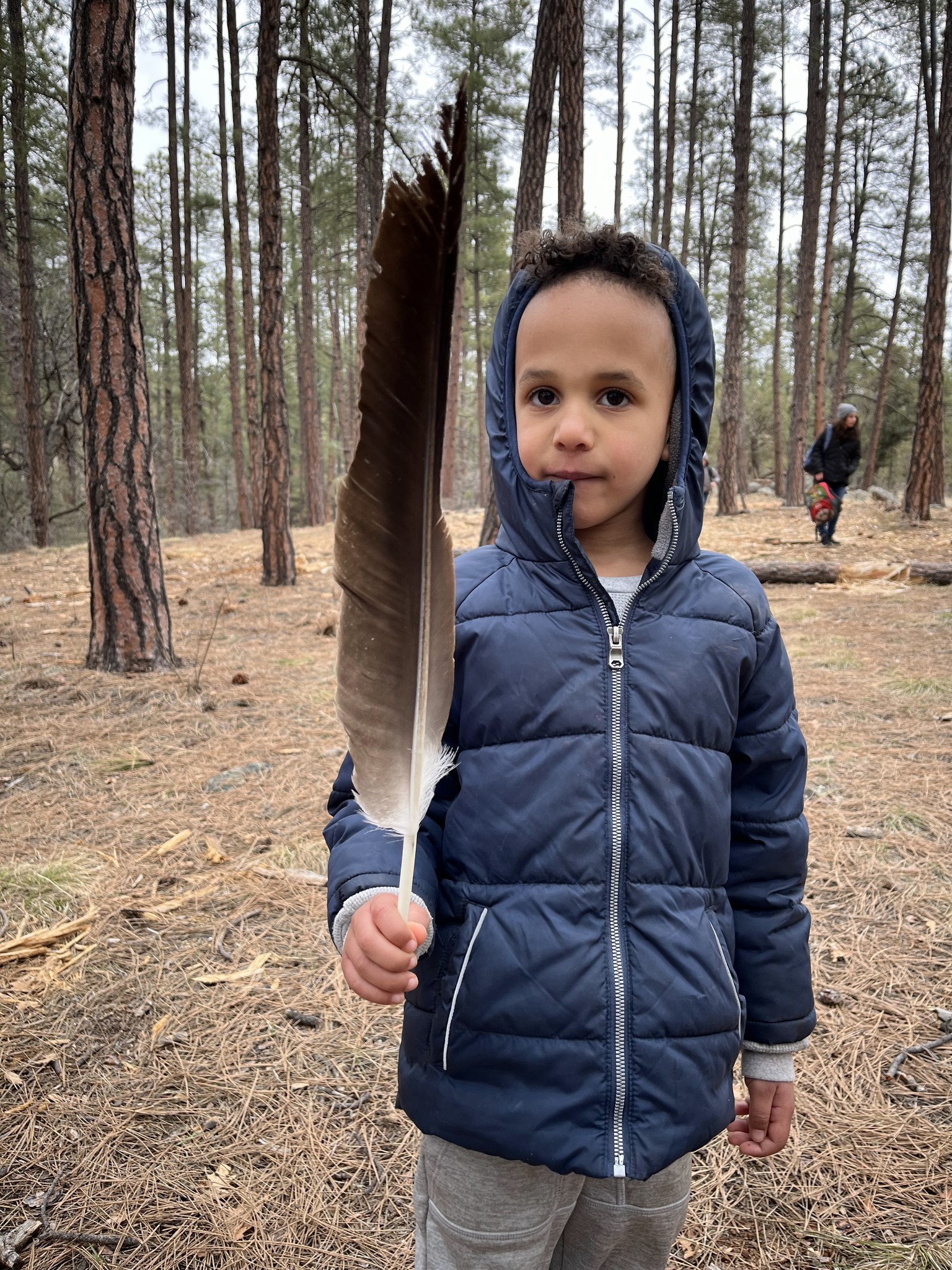 a child holds up a feather they found